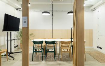 Nowoczesne i funkcjonalne biura na wynajem na ulicy Przemyslowa 12 w Krakowie, wyposażone w drewniane biurka i komfortowe krzesła, idealne do pracy zespołowej.