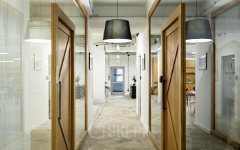 Nowoczesne powierzchnie biurowe z widocznymi elementami drewna i szkła, oświetlenie typu pendant w biurze przy Przemyslowa 12, Kraków.