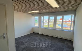 Unfurnished office space at Zwettestraat 15, Leeuwarden. Features a spacious room with large windows for natural light, suitable for an open floor plan. Ideal for those seeking an office space rental.