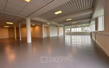 Interior view of a spacious, bright open floor plan at Zwettestraat 15, Leeuwarden featuring large windows and overhead lighting, ideal for office space rental.