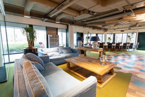 Interior office space at Schipholweg 103, Leiden with modern furnishings including blue sofas, wooden table, and conference room.
