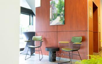 Interior of an office at Pompoenweg 3-15 in Leiden with two modern chairs, a small table, and a photo on the wall.