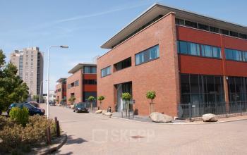 Exterior view of office buildings located at Pompoenweg 3 - 15 in Leiden, Leiden, showcasing modern brick architecture and large windows. Ideal for office space rental.