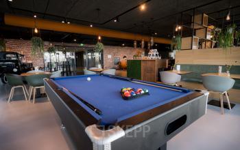 Modern lounge area with a pool table and seating, located at Bargelaan 200, Leiden, perfect for office space rental.