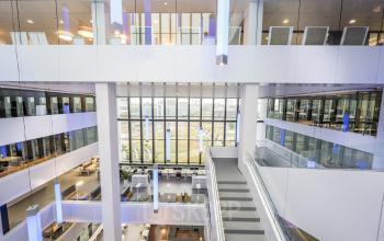 Modern multi-story office interior with open walkways, large windows, and workspaces at Bargelaan 200, Leiden.