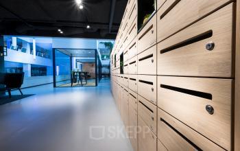 Modern workspace at Bargelaan 200, Leiden, with sleek wooden lockers and glass-walled meeting rooms, perfect for office space rental.