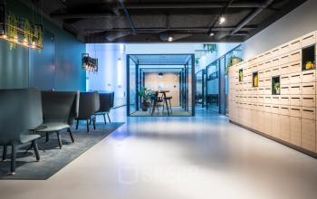 Modern open-floorplan office space at Bargelaan 200, Leiden, featuring contemporary seating, natural light, and sleek design, ideal for office space rental.