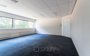 Unfurnished office space available for rent at Fruitweg 38, Leiden, featuring ample natural light and carpeting.