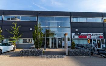 Exterior view of office space for rent located at Fruitweg 38 in Leiden, showcasing a modern facade with large glass windows and surrounding greenery.