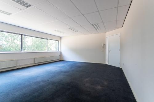 Unfurnished office space available for rent at Fruitweg 38, Leiden, featuring ample natural light and carpeting.