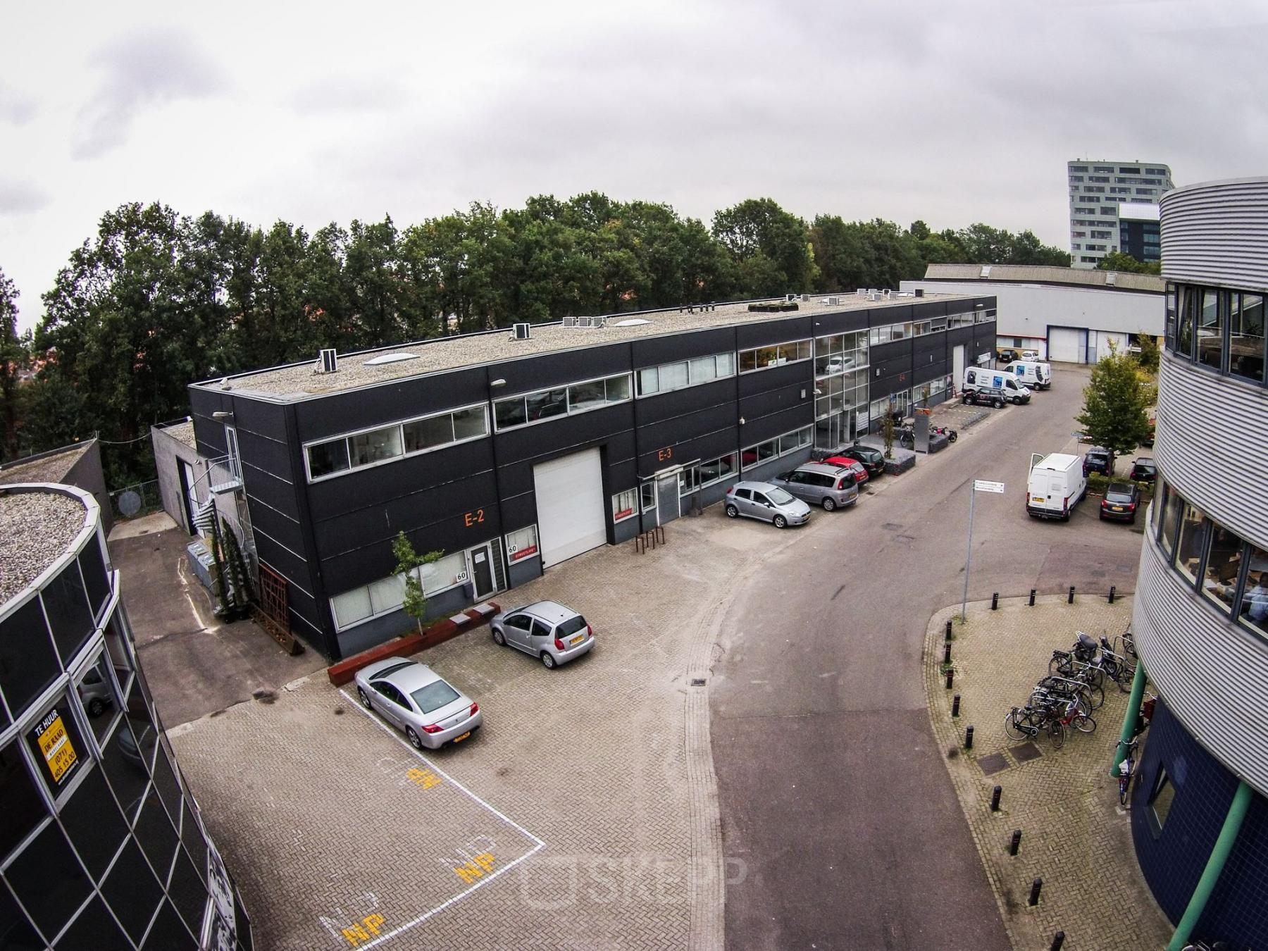 Aerial view of a business area at Fruitweg 38 in Leiden, showcasing various office spaces available for rent with parking access.
