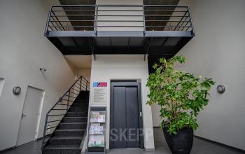 Spacious office entrance at Fruitweg 22, Leiden, available for rent. Features a modern interior with a staircase and elevator access.