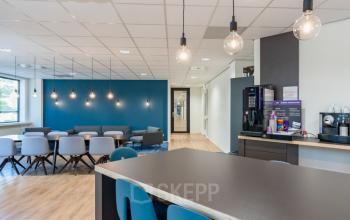 Modern and inviting office space rental at Schipholweg 55-89, Leiden, featuring contemporary furniture, ample lighting, and a cozy seating area with a coffee machine.