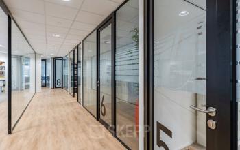 Modern office space at Schipholweg 55-89, Leiden with glass-walled rooms and wooden flooring, suitable for office space rental.