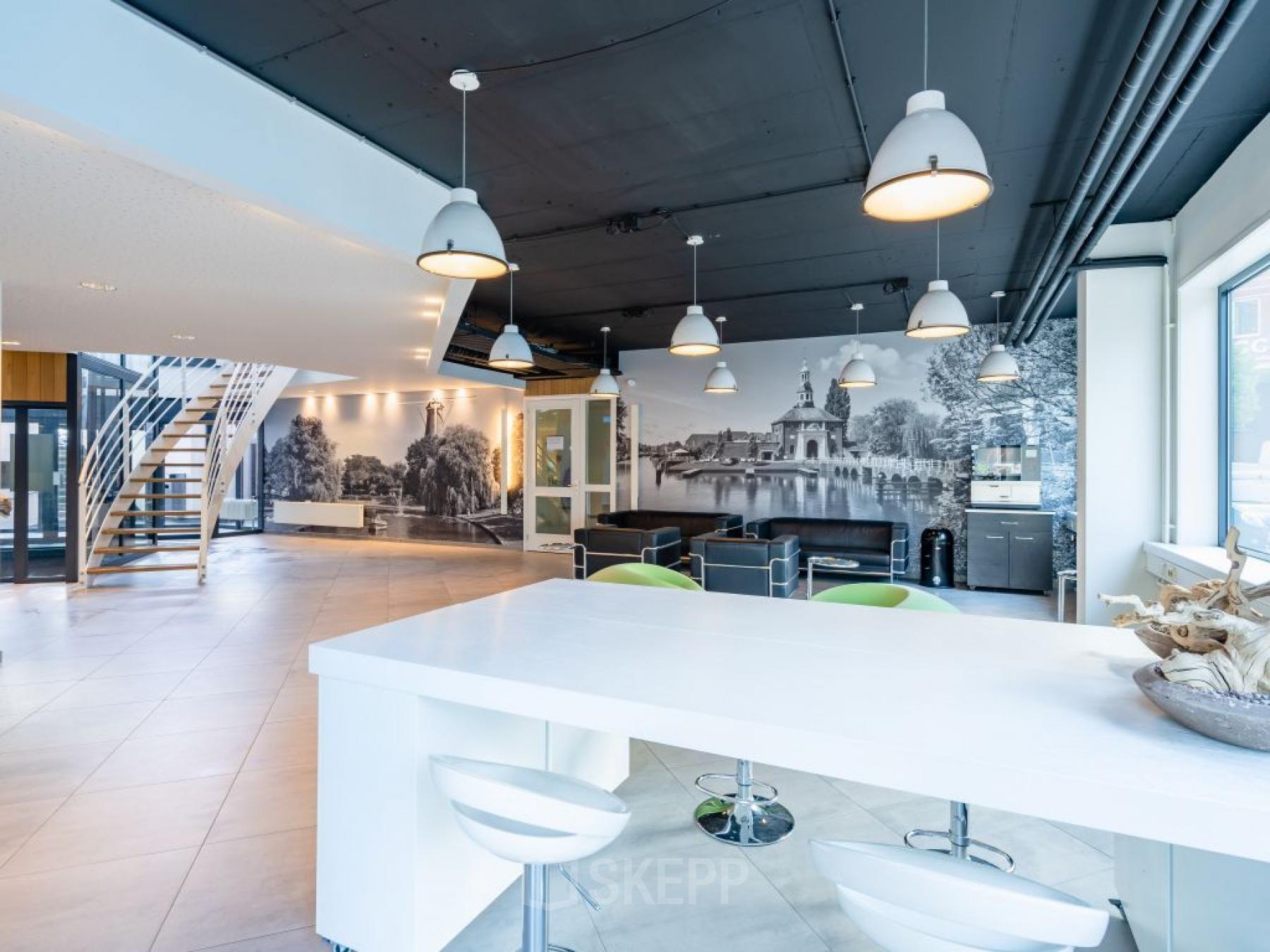 Modern office interior at Schipholweg 55-89, Leiden, featuring a bright workspace with white furniture and seating areas suitable for office space rental.