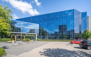 Modern glass-fronted building at Kanaalpark 140, Leiden, offering office space rental with an appealing exterior view.