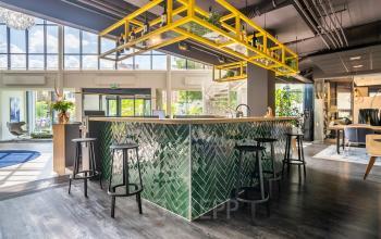 Spacious and modern reception area at Kanaalpark 140 in Leiden, perfect for those seeking office space rental. Features a stylish green-tiled counter and seating, ideal for welcoming clients.