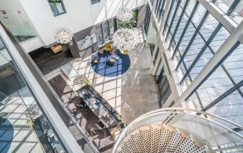 A modern office space at Kanaalpark 140 in Leiden featuring a spacious reception area with contemporary seating, plants, and decorative lighting. Ideal for office space rental.