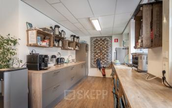Cozy and well-equipped kitchenette in office space rental at Kanaalpark 157, Leiden, with appliances and seating area.