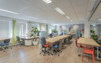 Modern, well-lit office space rental at Kanaalpark 157, Leiden, with desks, chairs, and decorative plants creating an inviting work environment.