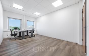 Spacious and bright office for rent at Het Ravelijn 1-11, Lelystad, featuring large windows, modern wood flooring, and a functional workstation setup.