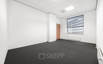 Bright, unfurnished office space available to rent at Het Ravelijn 1-11, Lelystad, featuring neutral walls and carpeted flooring, ideal for customizing your work environment.