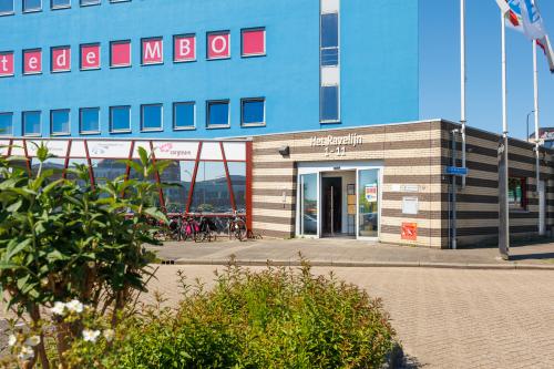 Exterior view of Het Ravelijn 1-11 in Lelystad, featuring modern architecture and a welcoming entrance, ideal for office space rental.