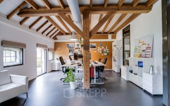 Spacious office at Hamersveldseweg 120, Leusden with exposed beams, modern furnishings, and natural light. Perfect for office space rental with a mix of collaborative and private work areas.