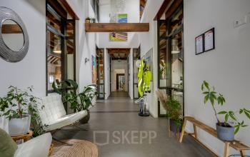 View of a bright, furnished office interior at Hamersveldseweg 120, Leusden, available for rent. The space features seating, plants, and décor, ideal for office space rental seekers.