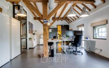 Spacious office space at Hamersveldseweg 120, Leusden, featuring modern desks and exposed wooden beams, available for rent. Ideal for office space rental.