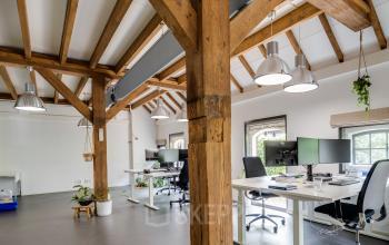 Bright office space at Hamersveldseweg 120, Leusden, with wooden beams, desks, and natural light, ideal for office space rental.