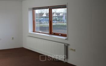 Interior office space with large window, radiator, and brown carpet at Zijakkertje 2, Limmen.