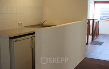 Interior of office space for rent at Zijakkertje 2, Limmen, featuring a small kitchenette area with a sink and refrigerator.
