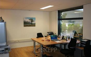 Modern office space rental at van Rietlaan 11, Linschoten, with neatly arranged desks, bright lighting, and a view outside.