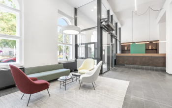 Die stilvolle Eingangshalle in der Promenade 23, Linz, bietet eine moderne Empfangsatmosphäre. Ideal für Unternehmen, die Bürofläche mieten möchten, mit einladenden Sitzmöglichkeiten und elegantem Design.