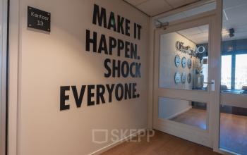 Office entrance at Horsterweg 24, Maastricht-Airport with motivational wall art and glass doors, ideal for office space rental.