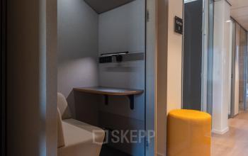Modern office pod at Maastricht-Airport, ideal for private calls or focused work, featuring a comfortable seat and desk. Perfect for office space rental seekers in a contemporary setting.