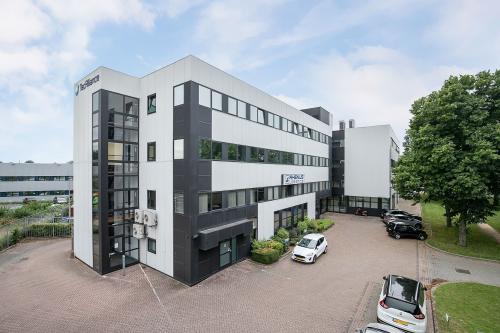 Modern office building at Horsterweg 24, Maastricht-Airport, ideal for office space rental, featuring a sleek exterior design with ample parking space.