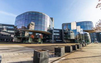 Modern office building at Avenue Ceramique 221, Maastricht, available for office space rental, featuring glass facades and spacious outdoor areas.