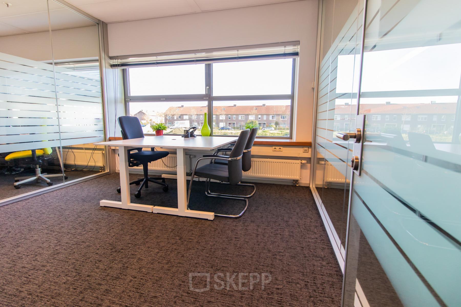 Bright office space with glass walls at Avenue Ceramique 221, Maastricht, featuring a desk and chairs ideal for office space rental.
