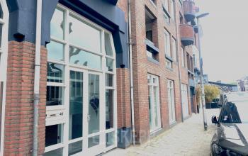 Exterior view of office space rental at Wilhelminasingel 44-46 in Maastricht, featuring a brick facade and large windows.