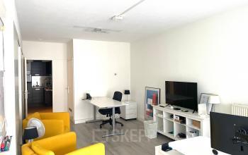 Bright office space with modern furnishings, including a desk and chairs, available for rent at Wilhelminasingel 44-46 in Maastricht.