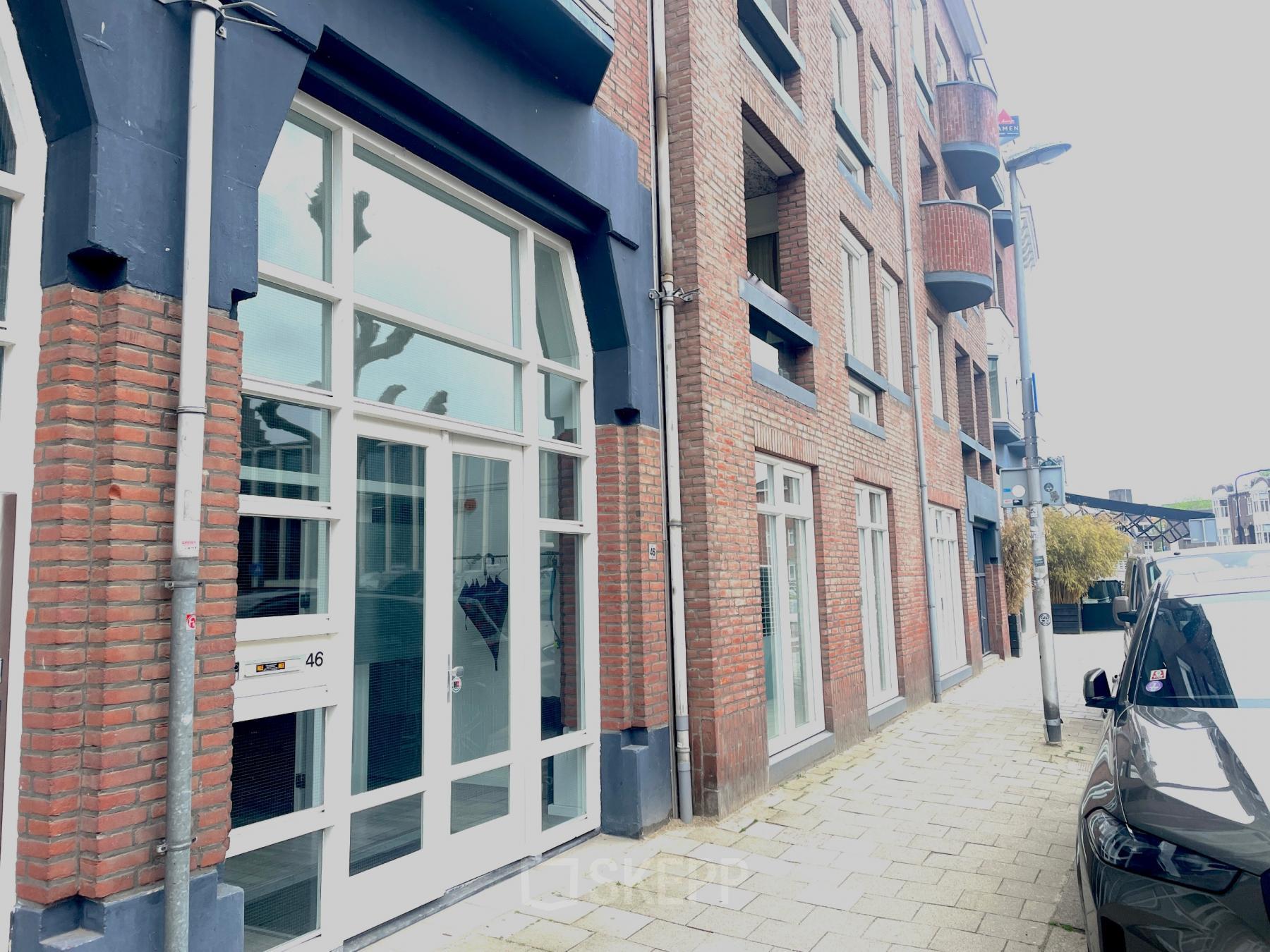 Exterior view of office space rental at Wilhelminasingel 44-46 in Maastricht, featuring a brick facade and large windows.