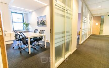 Bright office space at Robert Schumandomein 2, Maastricht, featuring a meeting room with modern chairs and a table. Ideal for rent office space seekers.
