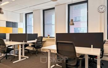 Bright office space with several desks, chairs, and dividers, ideal for those seeking office space rental at Robert Schumandomein 2, Maastricht.