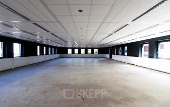 Spacious unfurnished office space for rent at Boschstraat 21 in Maastricht, featuring large windows and ample natural light.