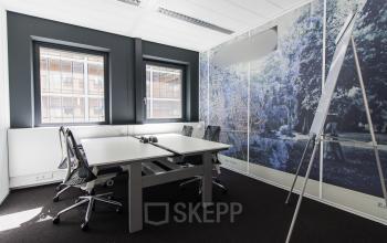 Modern office space rental at Boschstraat 21 in Maastricht featuring a well-lit room with desks, chairs, and a whiteboard.