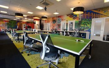 Colorful workspace interior at Boschstraat 21, Maastricht, with modern furniture and green tables.