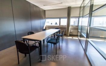 Bright, furnished office space rental in Made at Brieltjenspolder 28, featuring a meeting table and chairs with ample natural light.