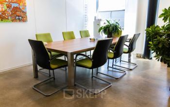 Bright office space with a modern table and green chairs, ideal for office space rental at Brieltjenspolder 28, Made.